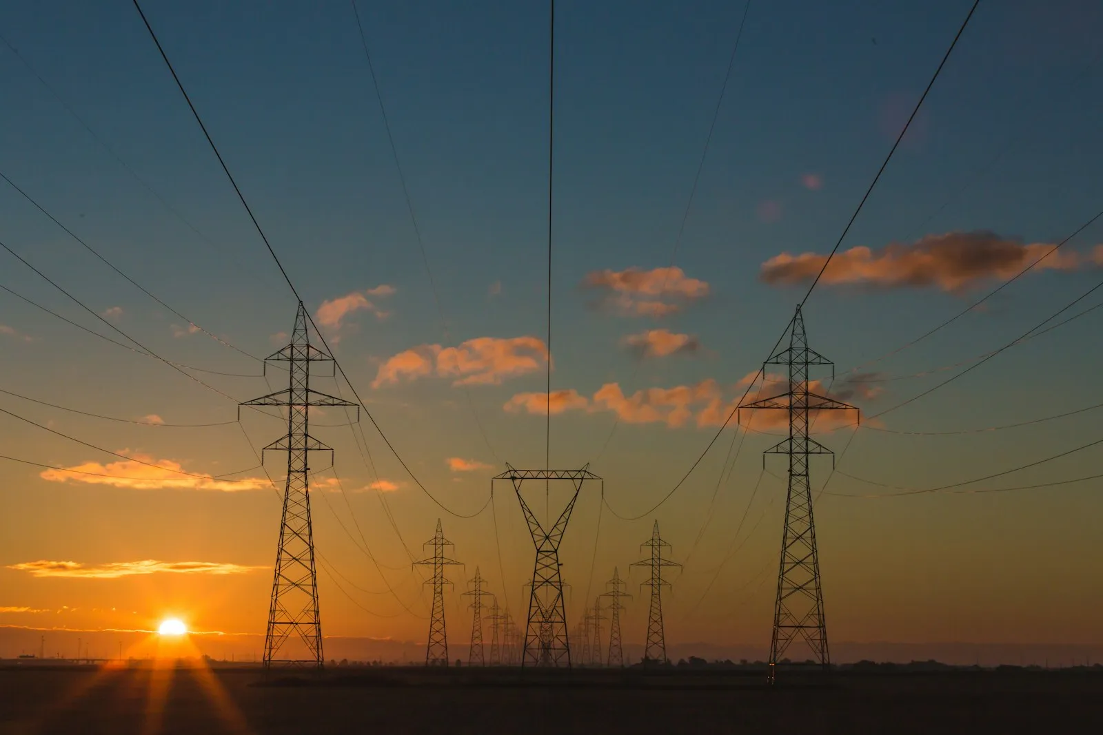 High-voltage transmission infrastructure at sunset, representing a grid connection and substation programme.
